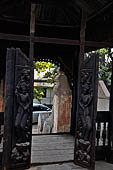 Old Bagan Myanmar. The Nat Taung monastery complex. High relief carved wooden pivot doors with dancing devas carrying floral sprigs. 